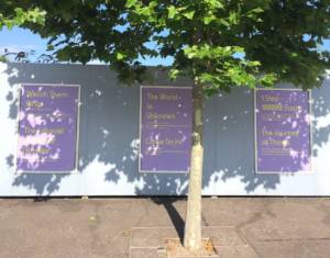 a photohgraph of hoarding boards with large posters featuring text based work by Claire Yspol