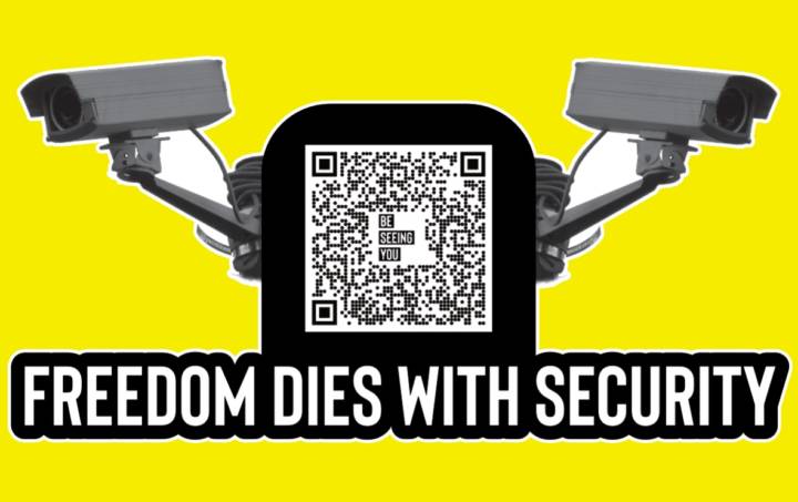 Yellow graphic with the words Freedom Dies with Security in large black outlined white letters. In the centre of the graphic there is a black and white image of two security cameras and a QR Code with the words BE SEEING YOU in the centre of it.