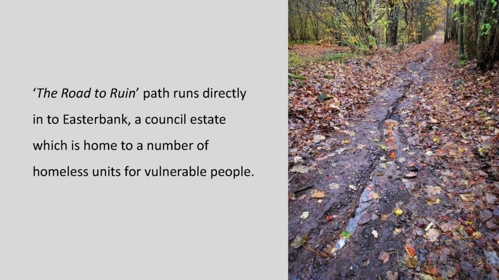 A wider shot of the previous stream of water running down a long woodland path. Black text to the left of the image reads: 'The Road to Ruin' path runs directly in to Easterbank, a council estate which is home to a number of homeless units for vulnerable people.